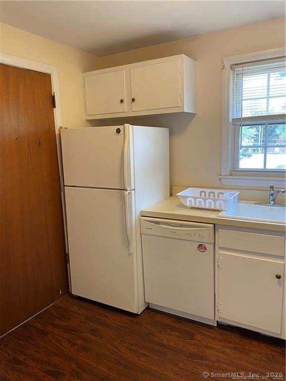 kitchen with dark wood-type flooring, white appliances, sink, and white cabinets