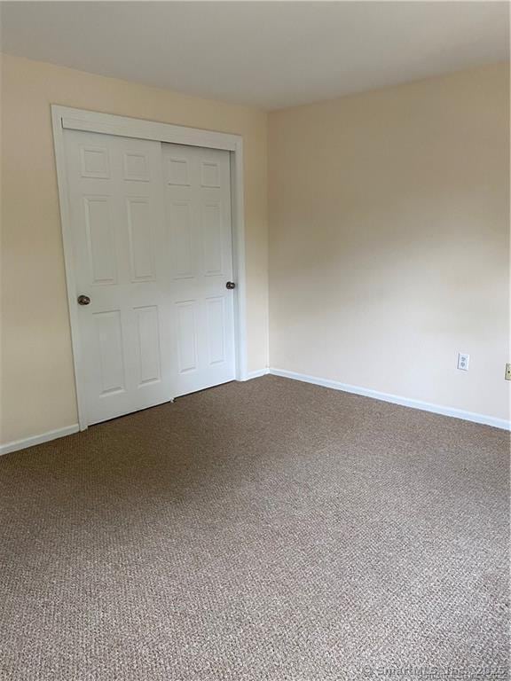 unfurnished bedroom featuring carpet flooring and a closet