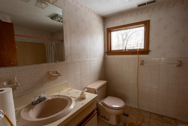 bathroom featuring vanity, toilet, curtained shower, and a textured ceiling