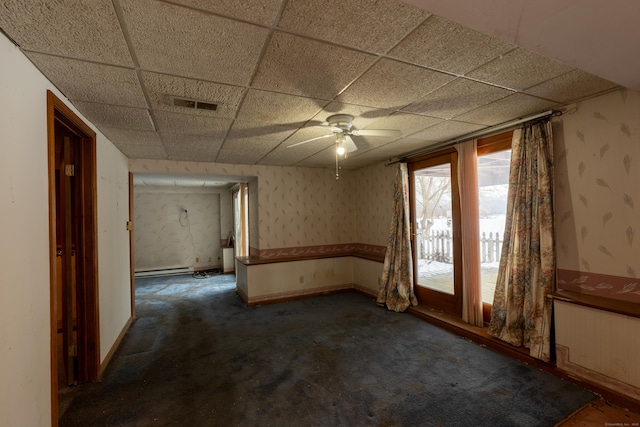 carpeted empty room with radiator, a paneled ceiling, and baseboard heating