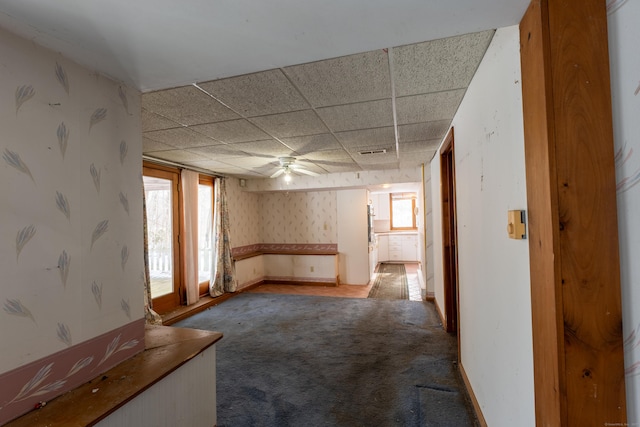 empty room featuring carpet, a paneled ceiling, and ceiling fan