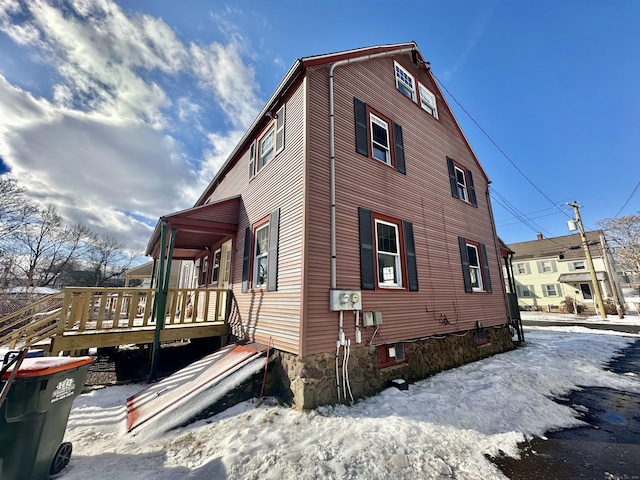 view of snowy exterior featuring a deck