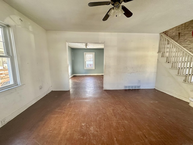 unfurnished living room with dark hardwood / wood-style floors and ceiling fan