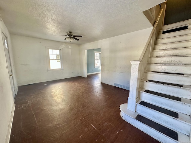 interior space with ceiling fan and a textured ceiling