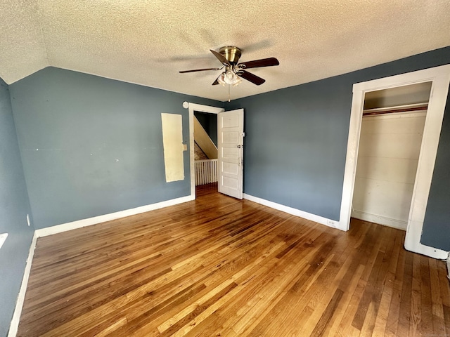 unfurnished bedroom with hardwood / wood-style flooring, ceiling fan, a textured ceiling, and a closet