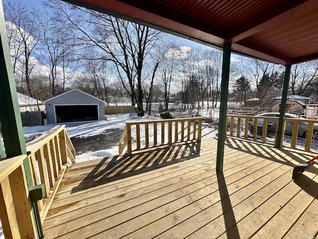 snow covered deck with an outbuilding and a garage