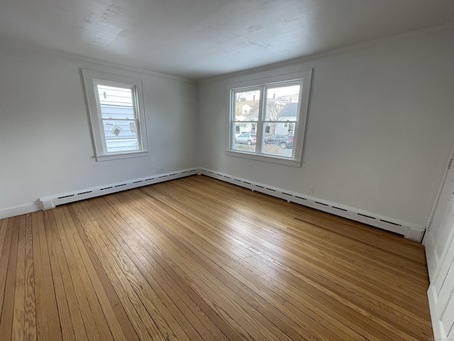 spare room featuring wood-type flooring, a healthy amount of sunlight, and crown molding