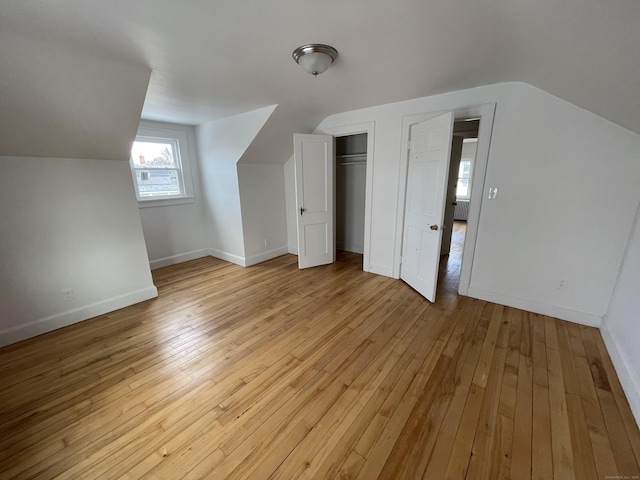 bonus room with lofted ceiling and light hardwood / wood-style flooring