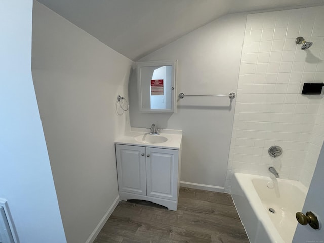 bathroom featuring lofted ceiling, tiled shower / bath combo, hardwood / wood-style floors, and vanity