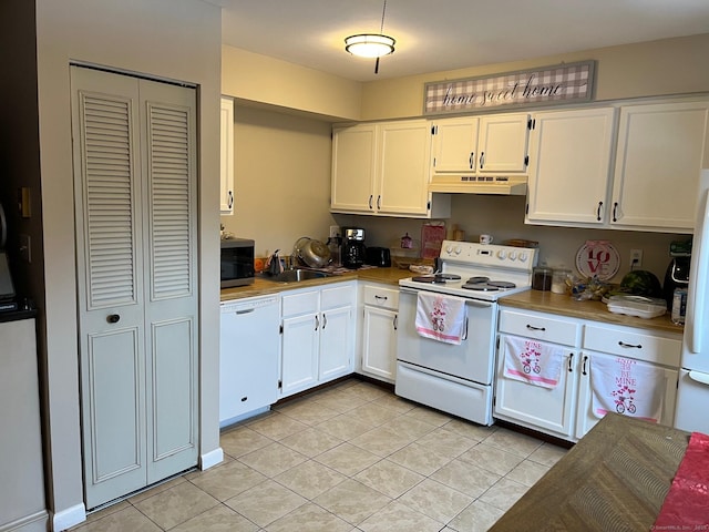 kitchen with white appliances, sink, light tile patterned floors, and white cabinets