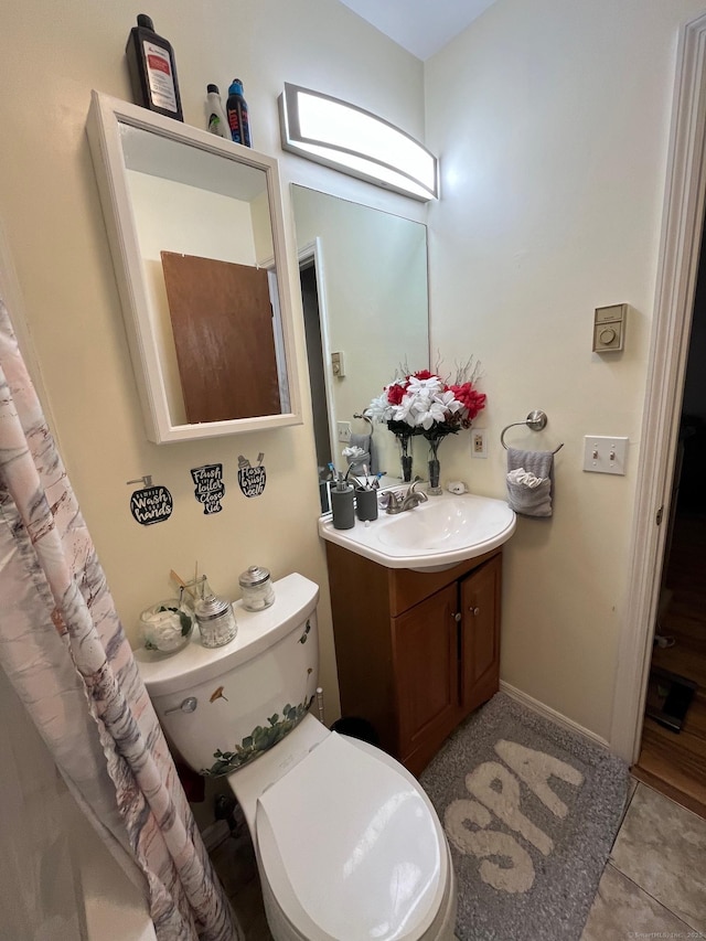 bathroom with tile patterned flooring, vanity, and toilet