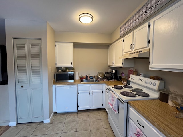 kitchen featuring sink, light tile patterned floors, white cabinets, and white appliances