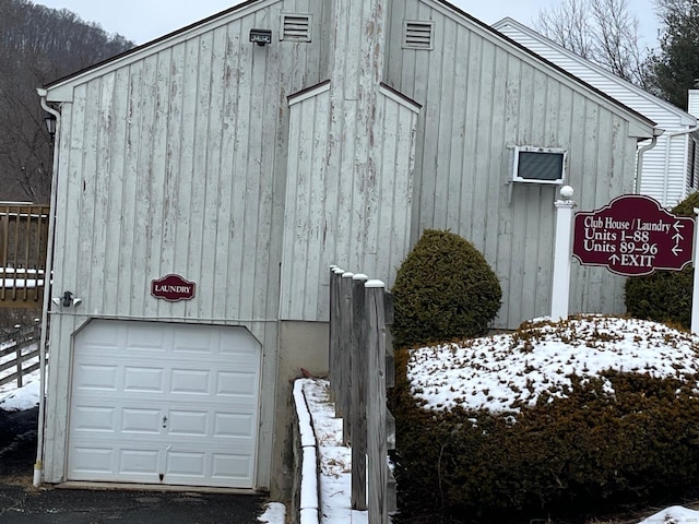 view of snow covered exterior featuring a garage