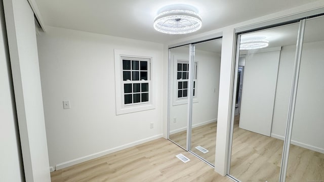 unfurnished bedroom featuring hardwood / wood-style flooring and two closets