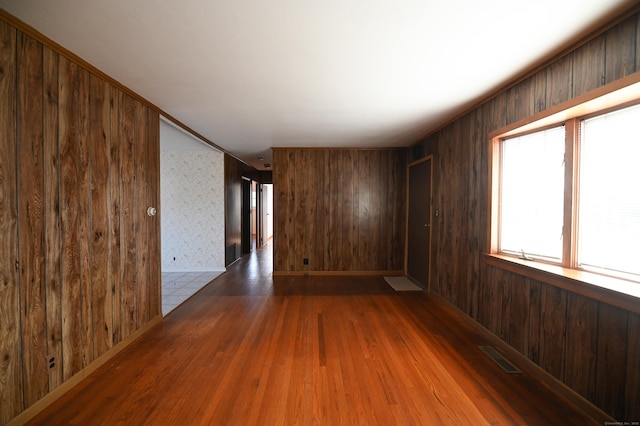 empty room featuring hardwood / wood-style flooring and wooden walls