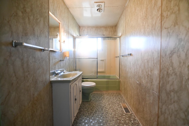 full bathroom featuring toilet, tile patterned floors, vanity, and shower / bath combination with glass door