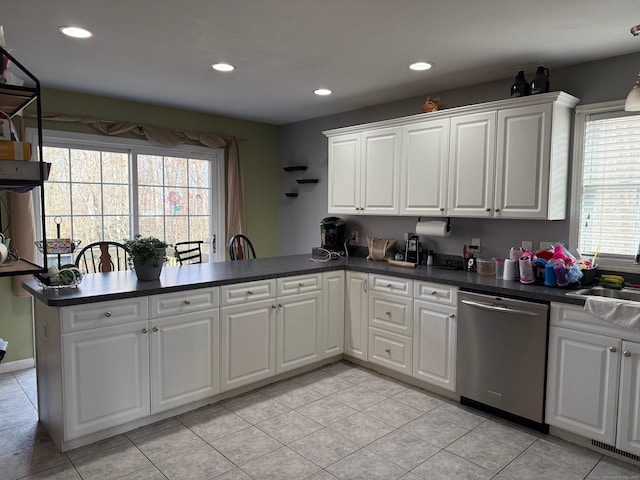 kitchen featuring light tile patterned flooring, dishwasher, kitchen peninsula, and white cabinets