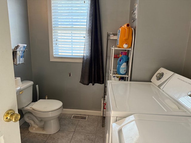 clothes washing area with light tile patterned flooring and washing machine and dryer