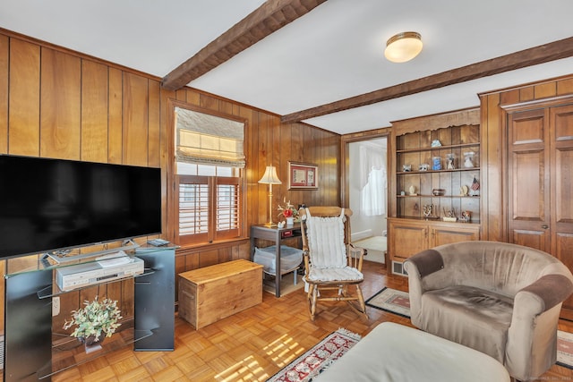 living room featuring beam ceiling, light parquet floors, and wood walls