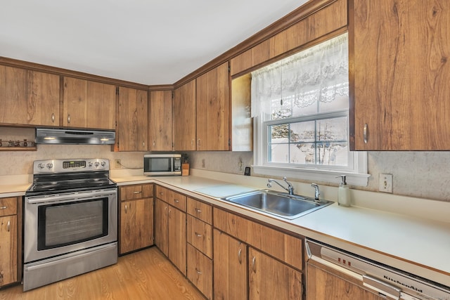 kitchen with stainless steel appliances, sink, and light wood-type flooring