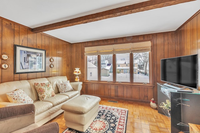 living room featuring light parquet floors, beam ceiling, and wood walls