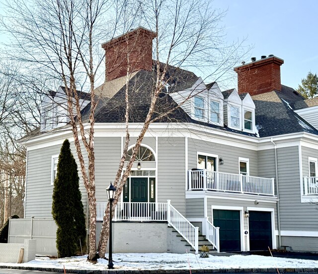 cape cod house with a garage and a balcony