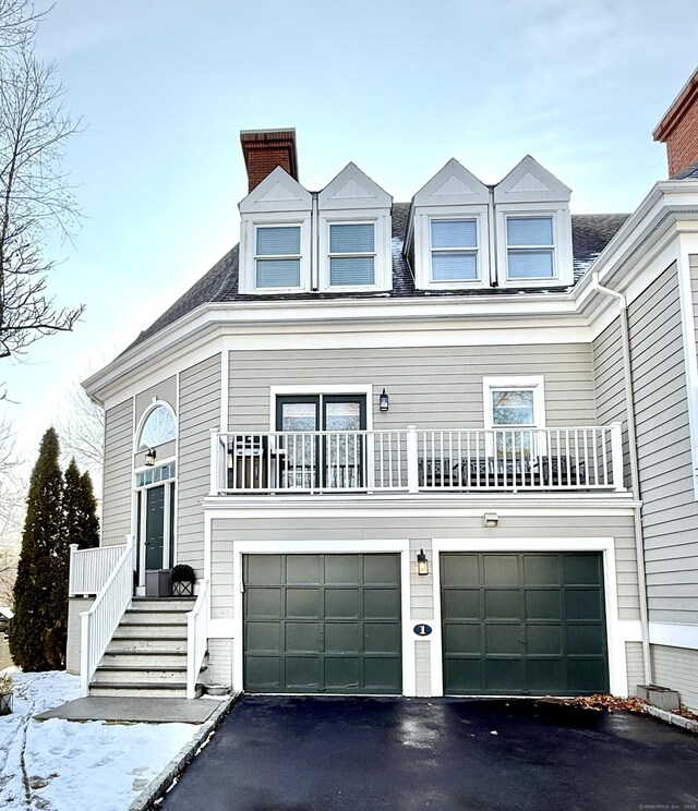 view of front of home featuring a garage and a balcony