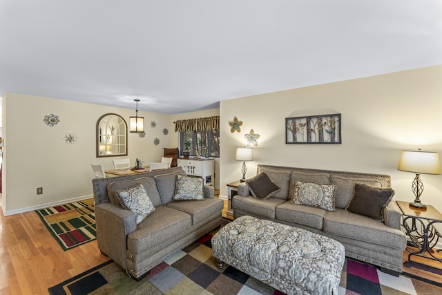 living area with baseboards and wood finished floors