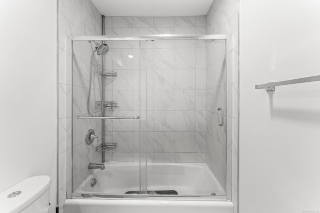 full bathroom featuring shower / bath combination with glass door and toilet