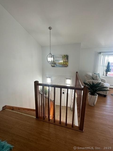 stairs with an inviting chandelier, hardwood / wood-style floors, and a baseboard heating unit