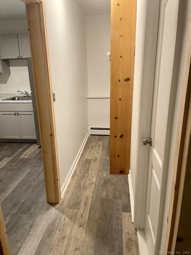 hallway featuring dark hardwood / wood-style flooring, sink, and baseboard heating