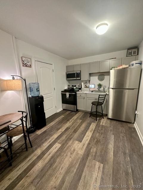 kitchen featuring dark wood-type flooring, appliances with stainless steel finishes, and gray cabinetry