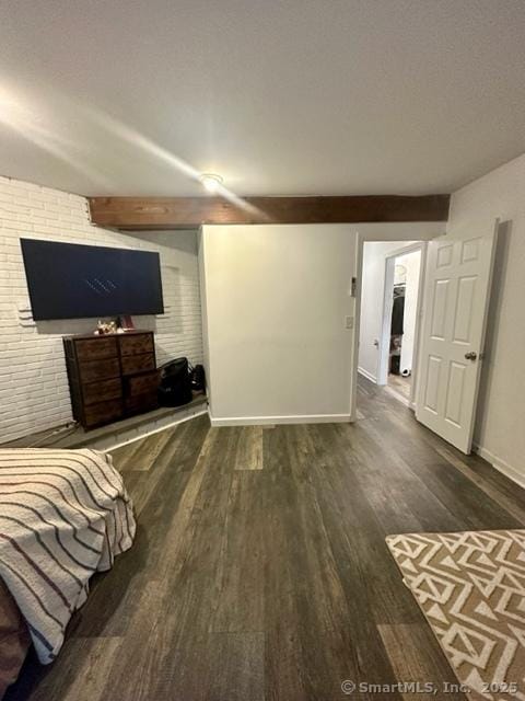 bedroom with beamed ceiling and dark hardwood / wood-style floors