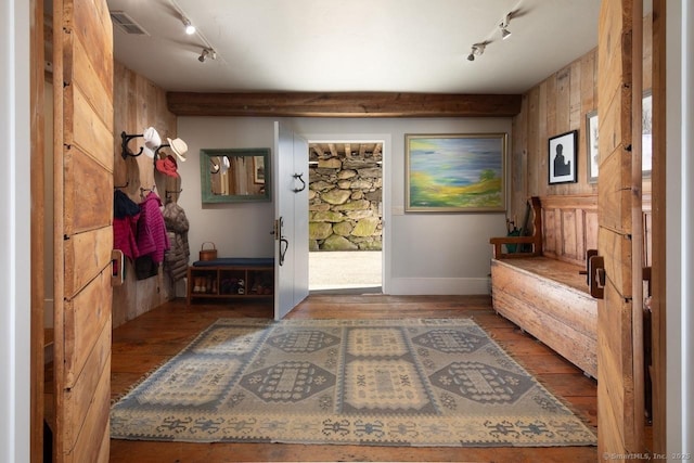 interior space featuring hardwood / wood-style flooring, wooden walls, and track lighting