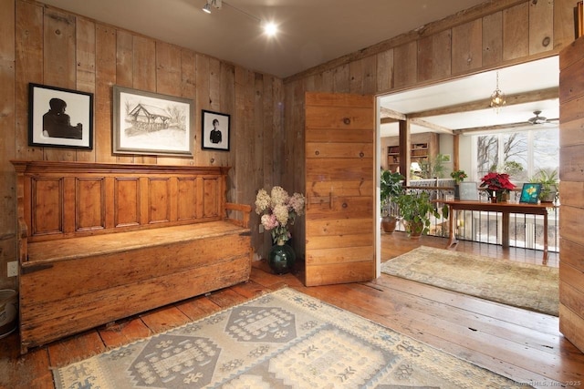 living area with hardwood / wood-style floors and wood walls