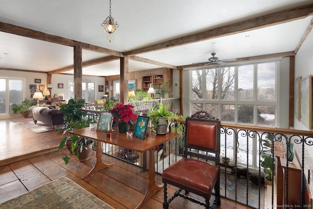 dining space with beamed ceiling, plenty of natural light, and wood-type flooring