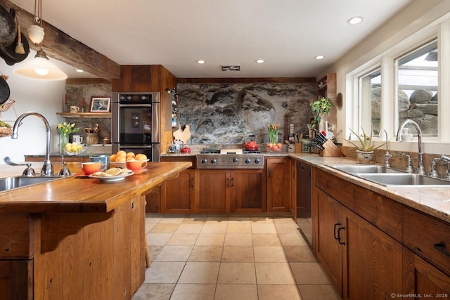 kitchen with stainless steel appliances, tasteful backsplash, sink, and wooden counters