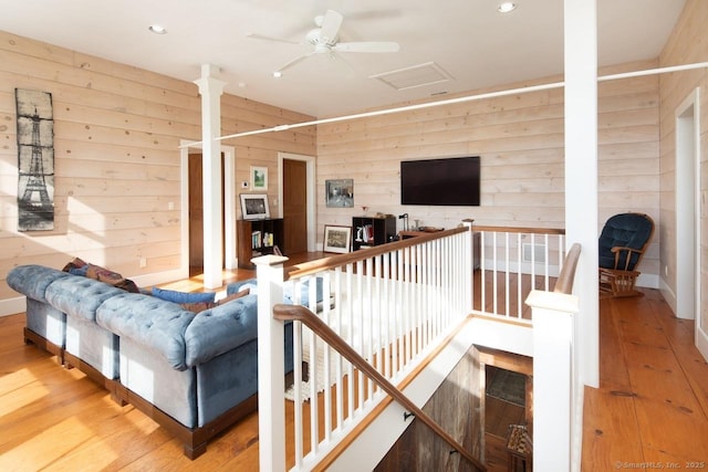 living room featuring hardwood / wood-style flooring and wooden walls