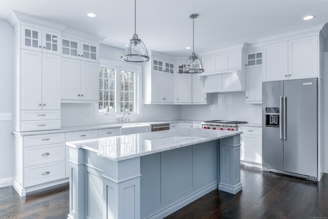 kitchen featuring a kitchen island, appliances with stainless steel finishes, decorative light fixtures, white cabinetry, and sink