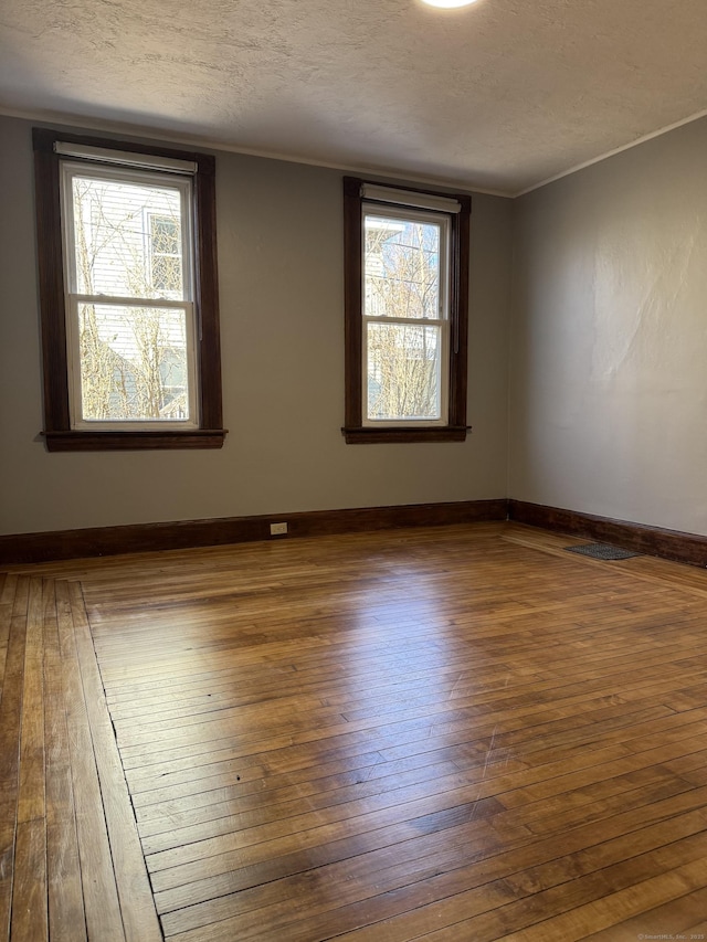 unfurnished room with dark hardwood / wood-style flooring, ornamental molding, and a textured ceiling