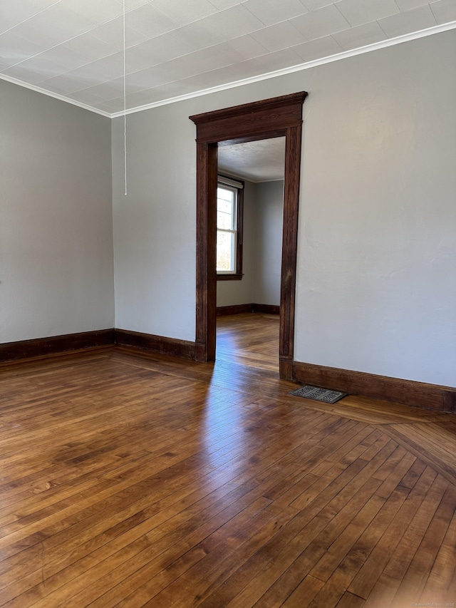 spare room featuring ornamental molding and dark hardwood / wood-style floors