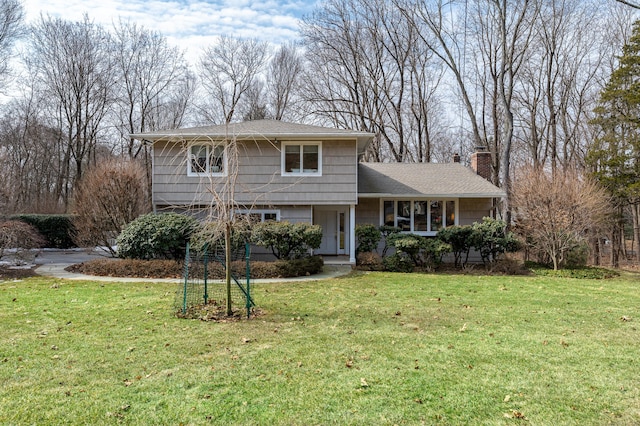 split level home featuring a front lawn and a chimney