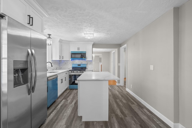 kitchen with white cabinetry, stainless steel appliances, a center island, and decorative backsplash