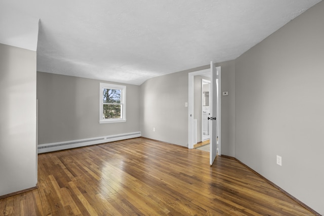 spare room with hardwood / wood-style flooring, a textured ceiling, and baseboard heating