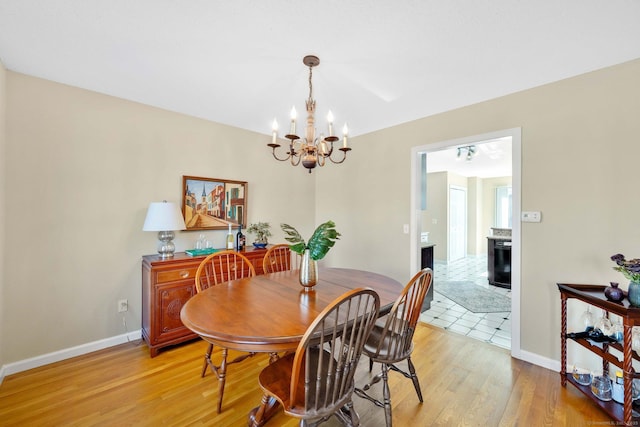 dining space featuring an inviting chandelier and light hardwood / wood-style flooring