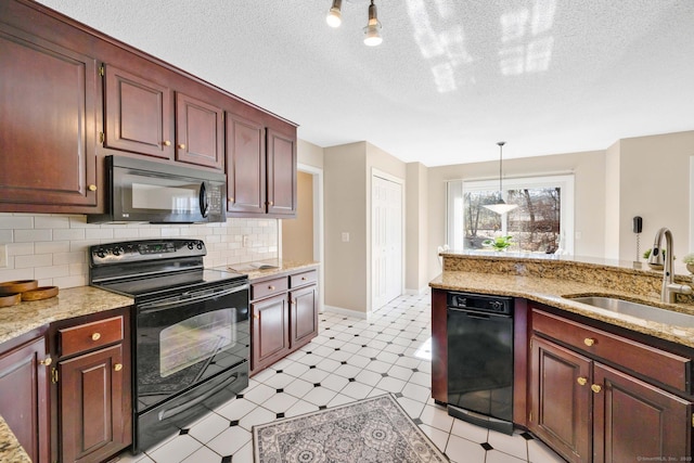 kitchen with pendant lighting, sink, decorative backsplash, light stone counters, and black appliances