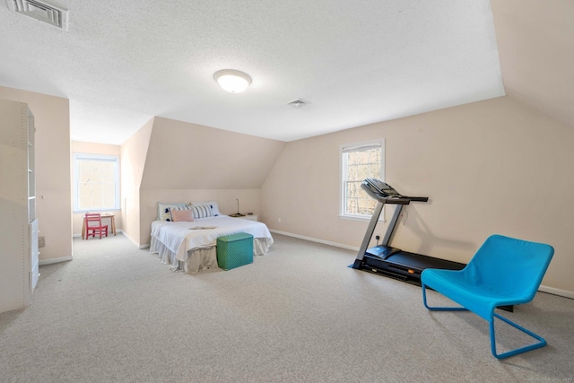 bedroom featuring lofted ceiling, light carpet, and a textured ceiling