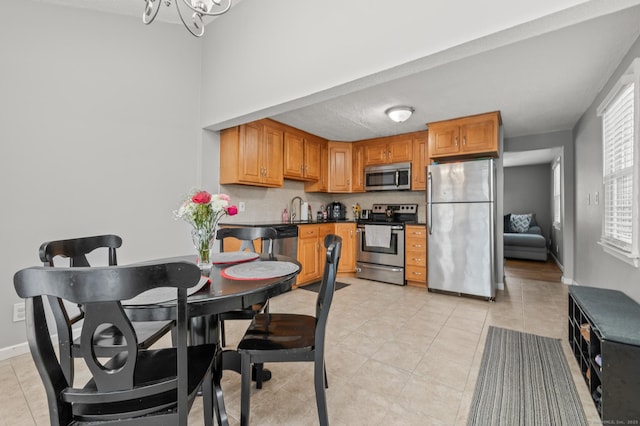 kitchen with appliances with stainless steel finishes, sink, and light tile patterned floors