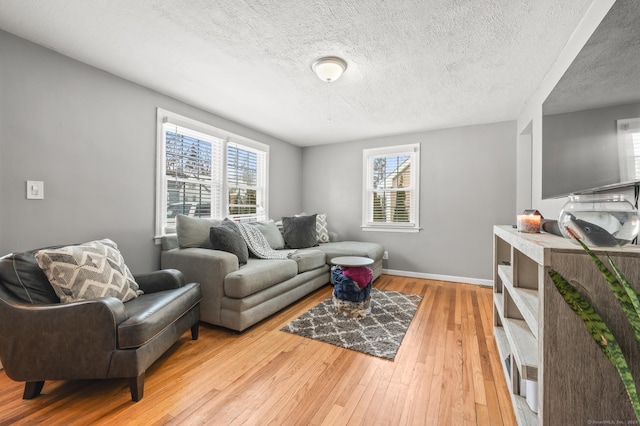 living room with light wood-type flooring and a textured ceiling