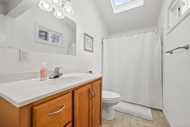 bathroom with toilet, tile patterned flooring, vanity, and vaulted ceiling with skylight